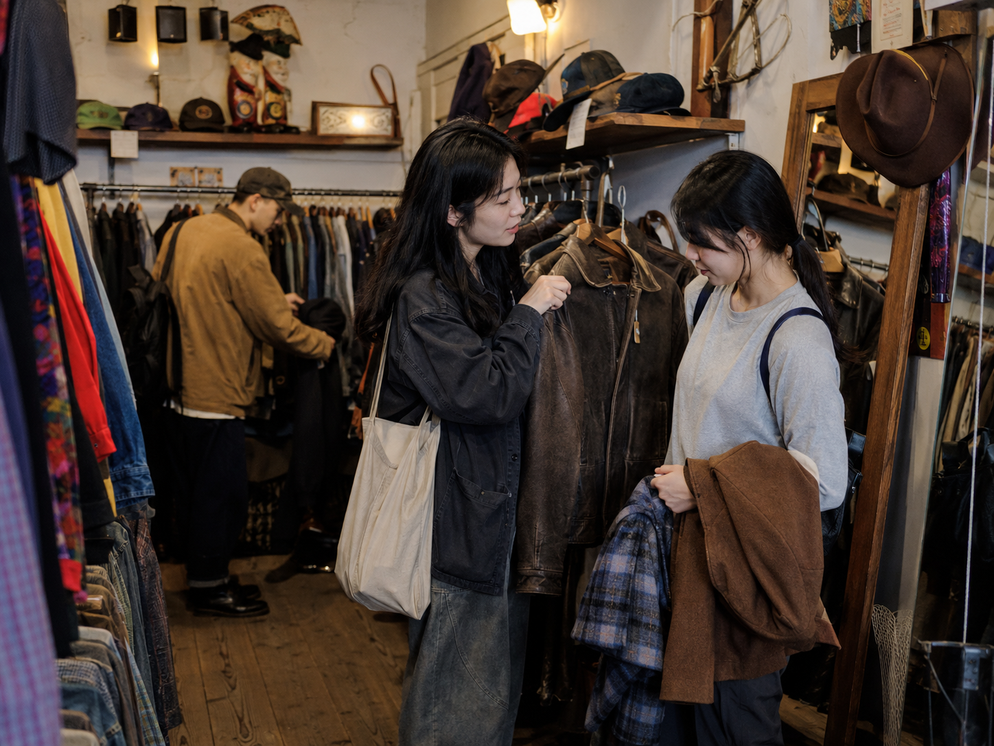 熟悉本地购物的人帮另一人在古着店挑衣服。